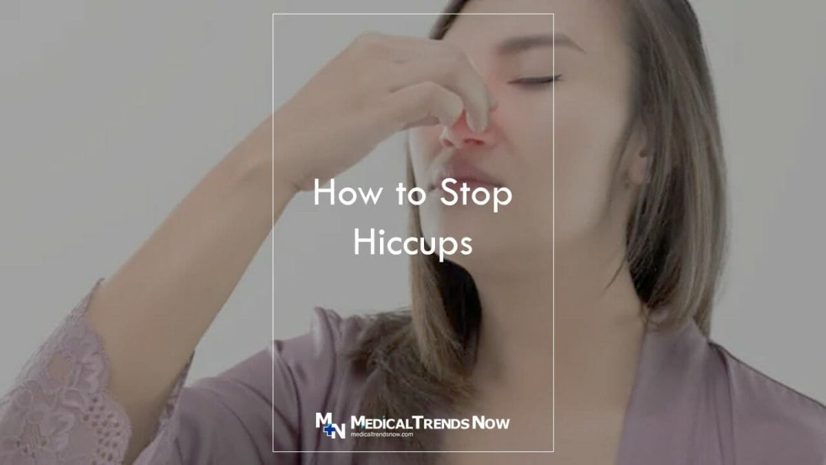 female pinching her nose to remove hiccups