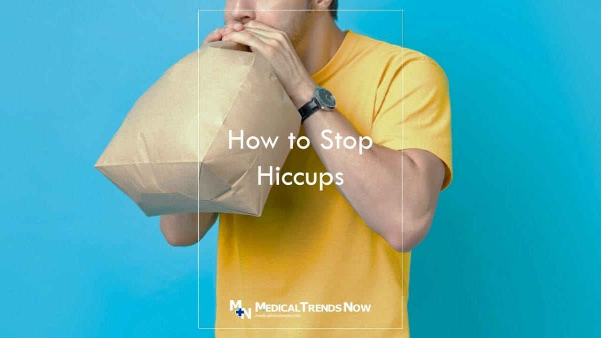male breathing in a paper bag to remove hiccups