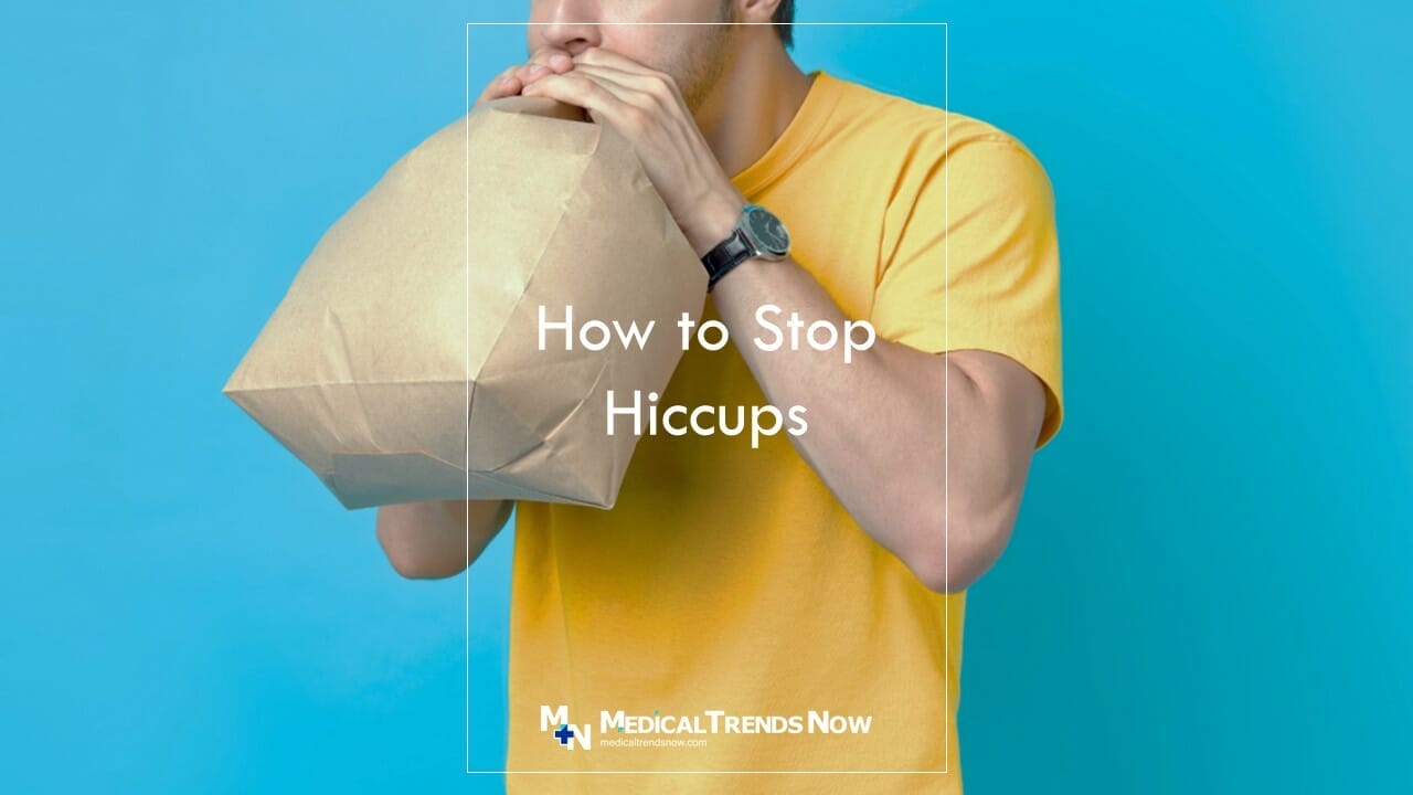 male breathing in a paper bag to remove hiccups